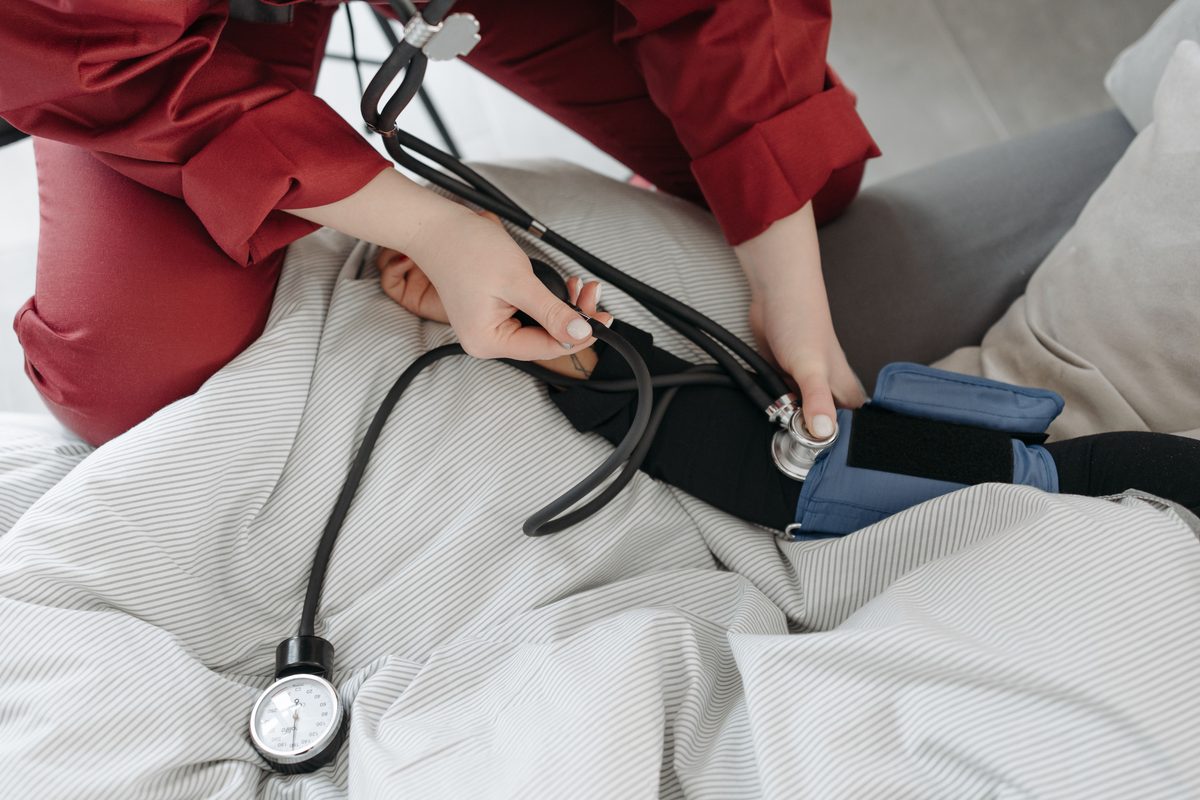 A nurse taking a patient's blood pressure at home