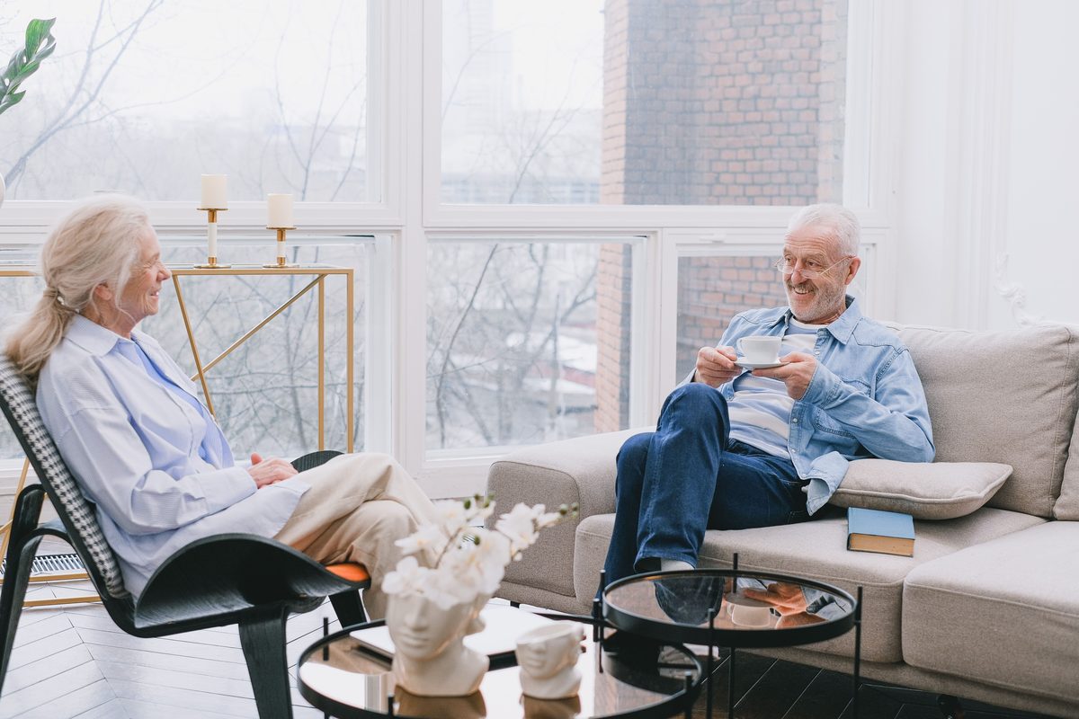 Two people talking in a sunlit living room
